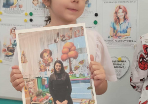 Dziewczynka trzyma zdjęcie pani nauczycielki z grupy drugiej