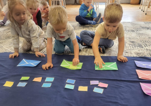 dzieci układają zanczki w kolorach kopert