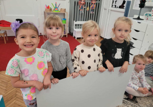 Dzieci z dużym pustyma kartonem jako kartka pocztowa