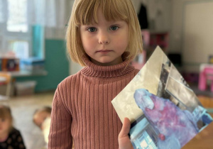 Dziewczynka pokazuje zdjęcie swojej papugi