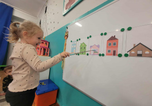 Dziewczynka przelicza okna w fioletowym domu