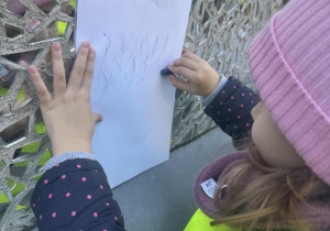 Dziewczynka odbija na kartce szkiełka