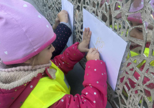 Dziewczynka kredką odbija ścianę ze szkiełkami