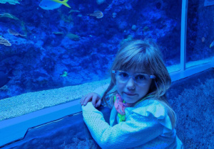 Dziewczynka na tle płynących ryb