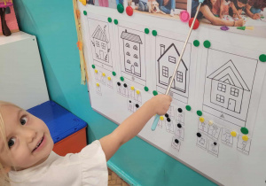 Dziewczynka wskazuje na ilustracji mamę