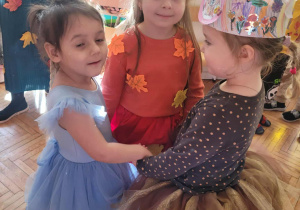 Dziewczynki tańczą w trzy w kole