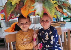 dwóch chłopców pod jesiennym parasolem