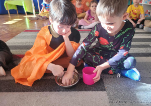 Dzieci wybierają pestki dyni z miski