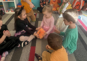 dzieci podają dynie w kole