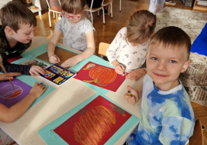 Dzieci przy stoliku rysują dynie