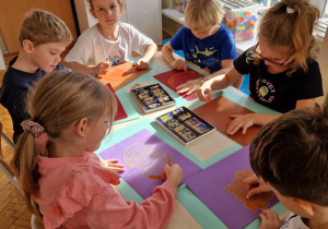 Dzieci tworzą obrazy z dyni