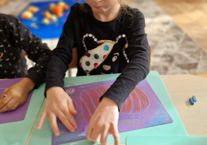 Dziewczynka maluje dynie na pomarańczowo