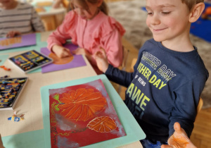 Chłopiec z namalowanymi dwoma dyniami