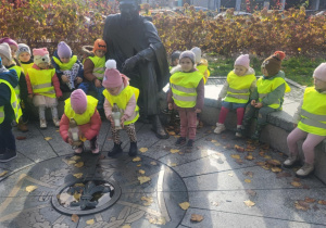 Dzieci zapalają znicz pod pomnikiem harcmistrza