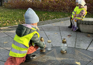 Dziewczynka stawia znicz