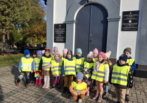 Dzieci przed wejściem na cmentarz wojskowy