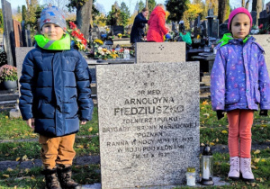 Dzieci przed tablicą poległych żołnierzy