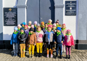 Starszaki przed wejściem na cmentarz wojskowy na Dołach