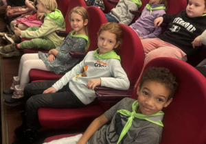 Dziieci starszaki siedzą na krzesłach