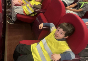 Dzieci z grupy trzeciej siedzą na krzesłach