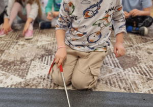 Chłopiec wskazuje litery w wyrazie lalka