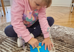 Dziewczynka kreśli po sladzie literę l