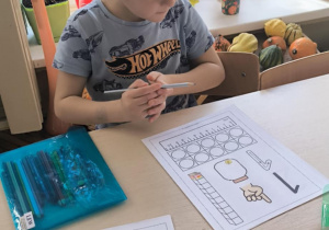 Chłopiec z kartą pracy z cyfra jeden