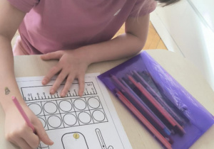 Dziewczynka zamalowuje jeden kwadrat