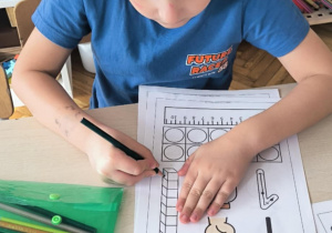 Chłopiec zamalowuje jeden kwadrat