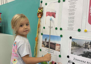 Dziewczynka pokazuje ilustrację z flagą Polski