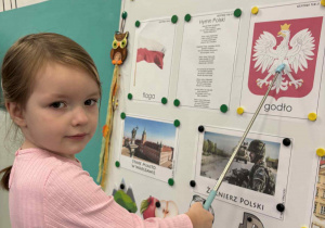 Dziewczynka pokazuje ilustrację z godlem