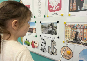 Dziewczynka pokazuje Syrenkę Warszawską