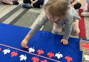 Dziewczynka kładzie jeden biały liść