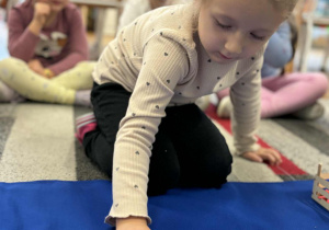 Dziewczynka odtwarza wzór z liści