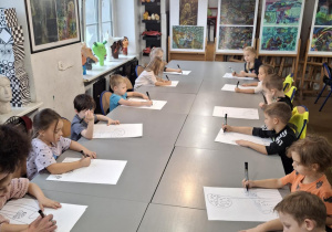 Dzieci siedzą w pracowni plastycznej