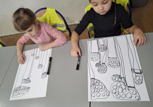 Dziewczynki z narysowanymi muchomorami na kartce