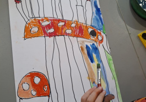 Dziecko maluje tło na kolorowo