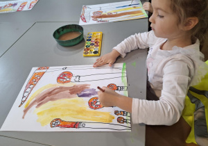 Dziewczynka maluje tło na żółto