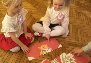 Dziewczynki łączą elementy puzzli