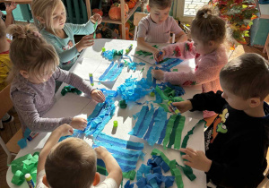 Dzieci przyklejaja bibułę