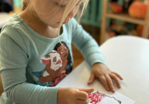 Dziewczynka patyczkiem robi kropki