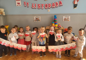 dzieci stją z napisem kocham cię polsko