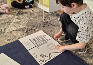 Chlopiec przykłada puzzel z monetami