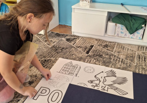 Dziewczynka przyklada puzzel z sylabą PO