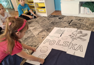 Dziewczynka przykłada puzzel z monetami