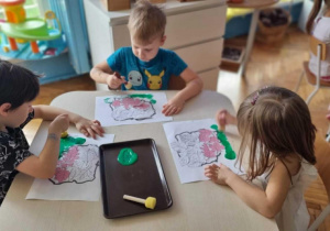 Dzieci maluja kartkę na zielono