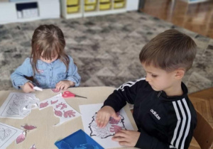 Chłopiec przykleja białe liście