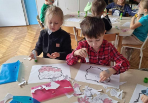 Chłopcy przyklejaja liście