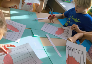 Dzieci wycinaja po lini tworząc puzzle