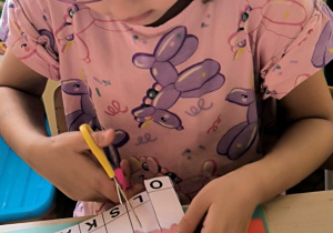 Dziewczynka składa obrazek z części